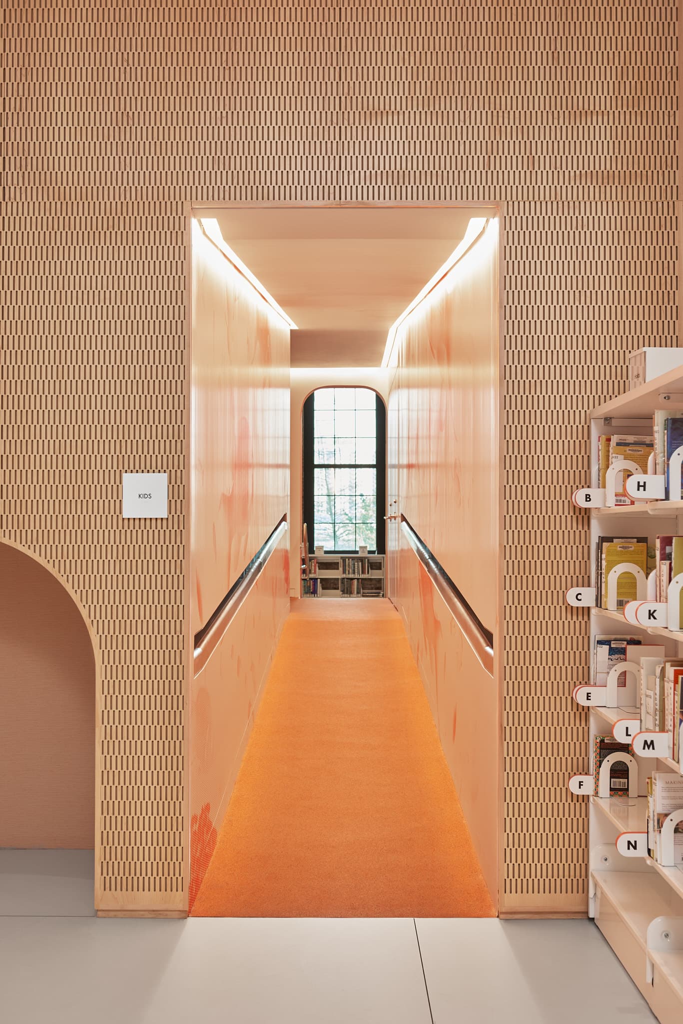 View into the kids tunnel, with the hold shelves and "Kids" sign in the middle ground