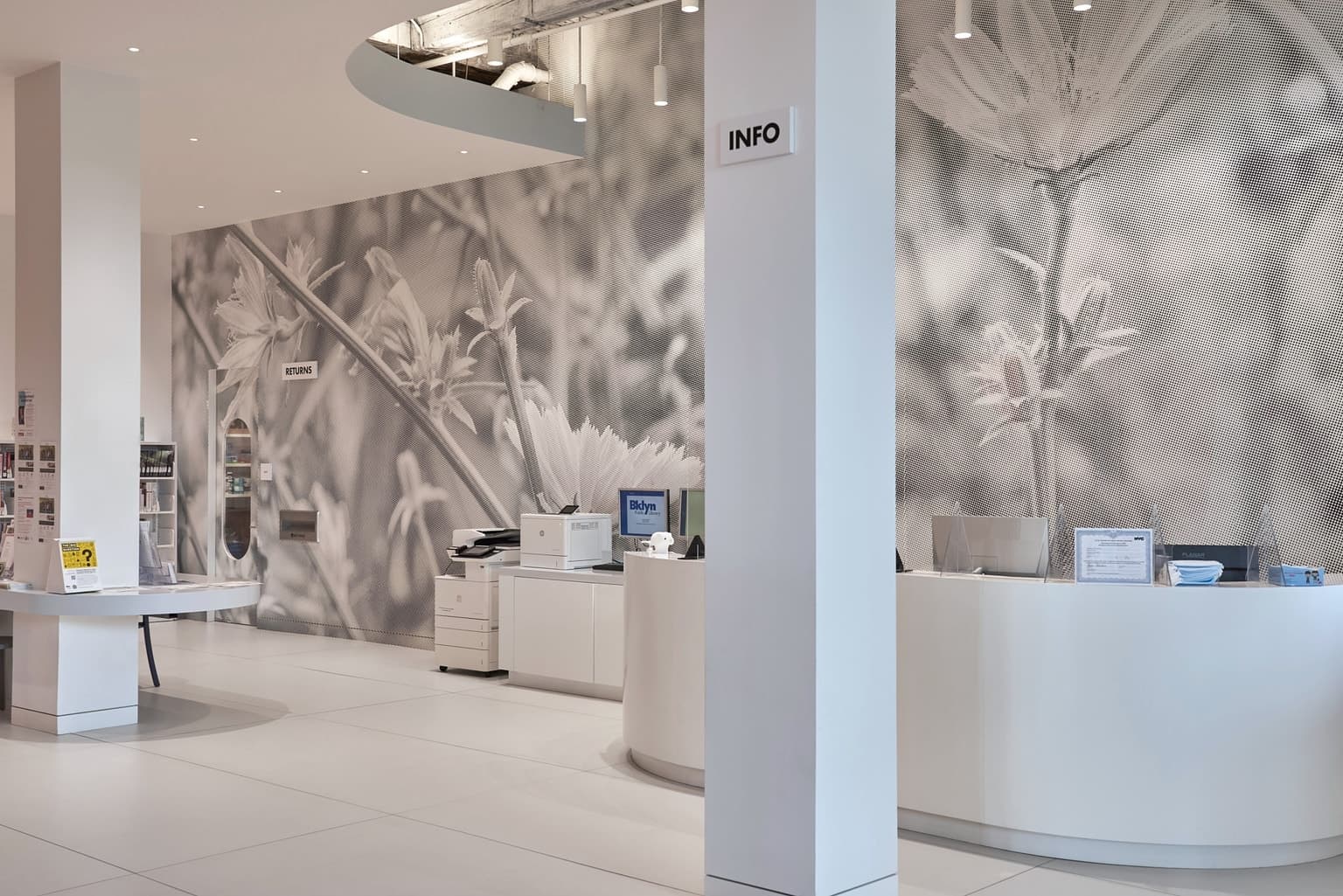 The info desk inside the library, with the word "Info" and a giant halftone wall mural of flowers